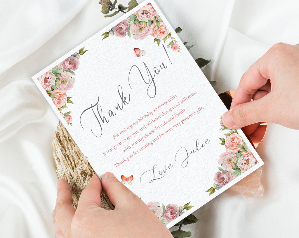Card with floral design and text held by hands on a light background