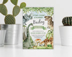 Dinosaur-themed birthday invitation leaning against a white wall next to cacti in pots