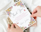 Floral thank you card held by hands on a light background