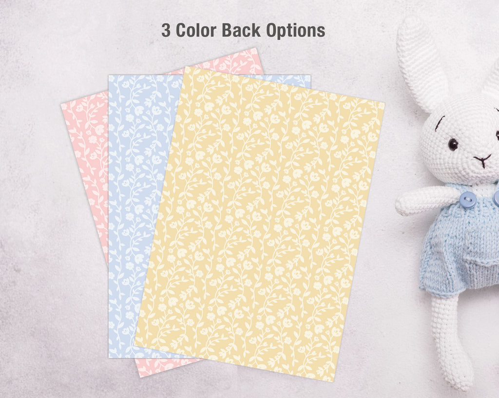 Three different colored invite backs next to a white stuffed animal toy on a light gray background.