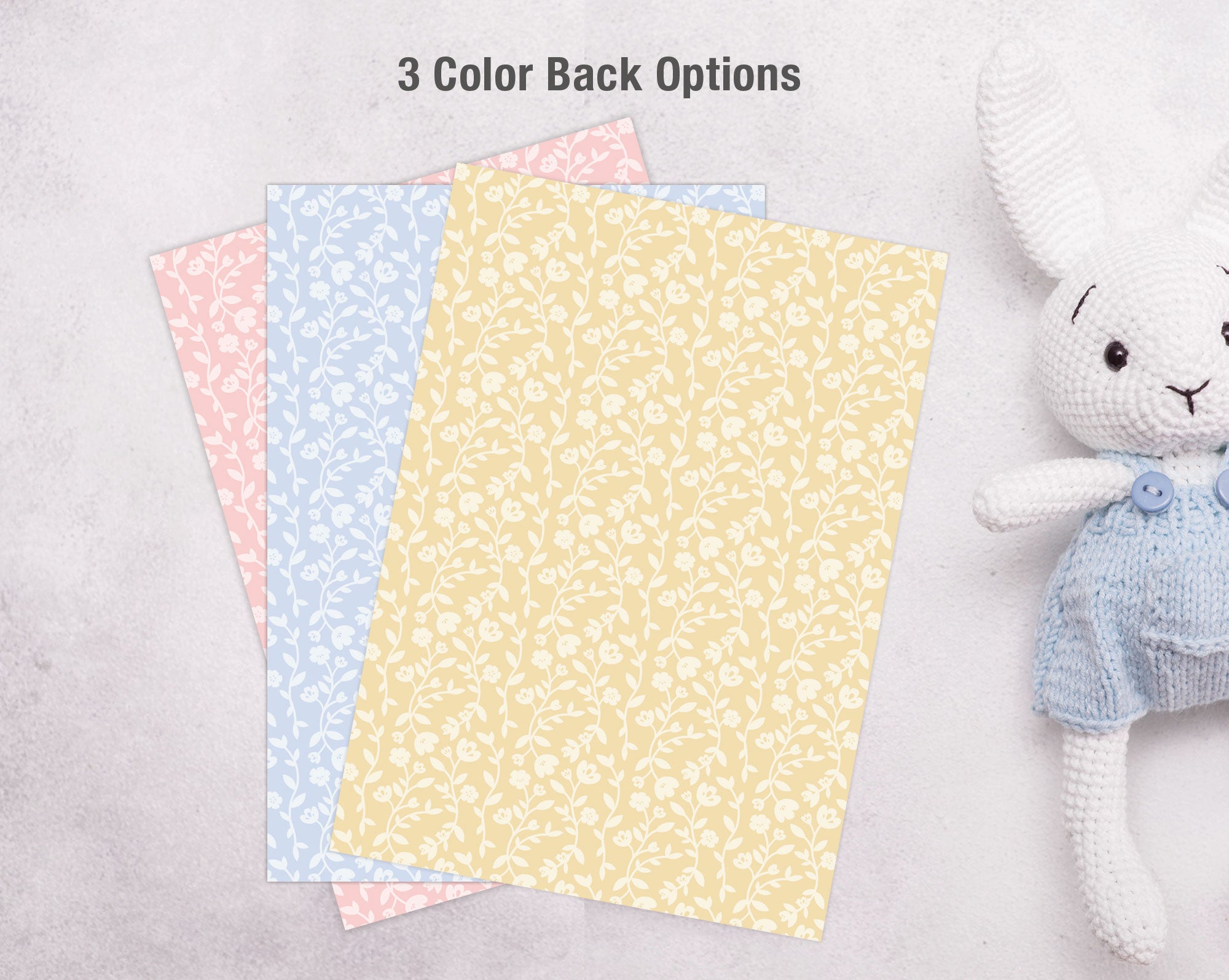 Three different colored invite backs next to a white stuffed animal toy on a light gray background.