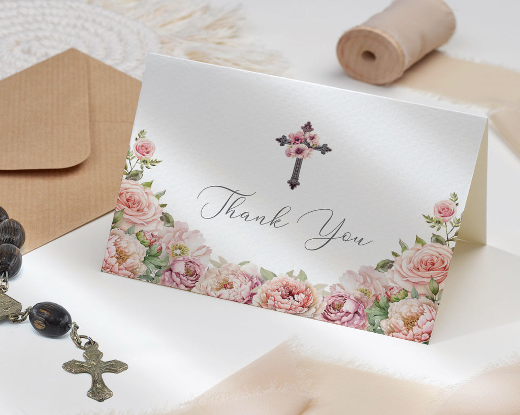 folded Thank You Card with blush pink floral design on a white background next to a brown envelope, ribbon and a rosary