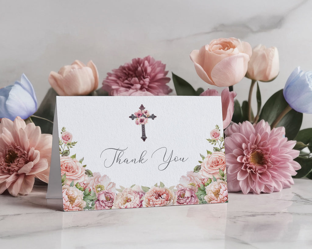Floral card with 'Thank You' message inside and christian cross in front of flowers on a marble surface