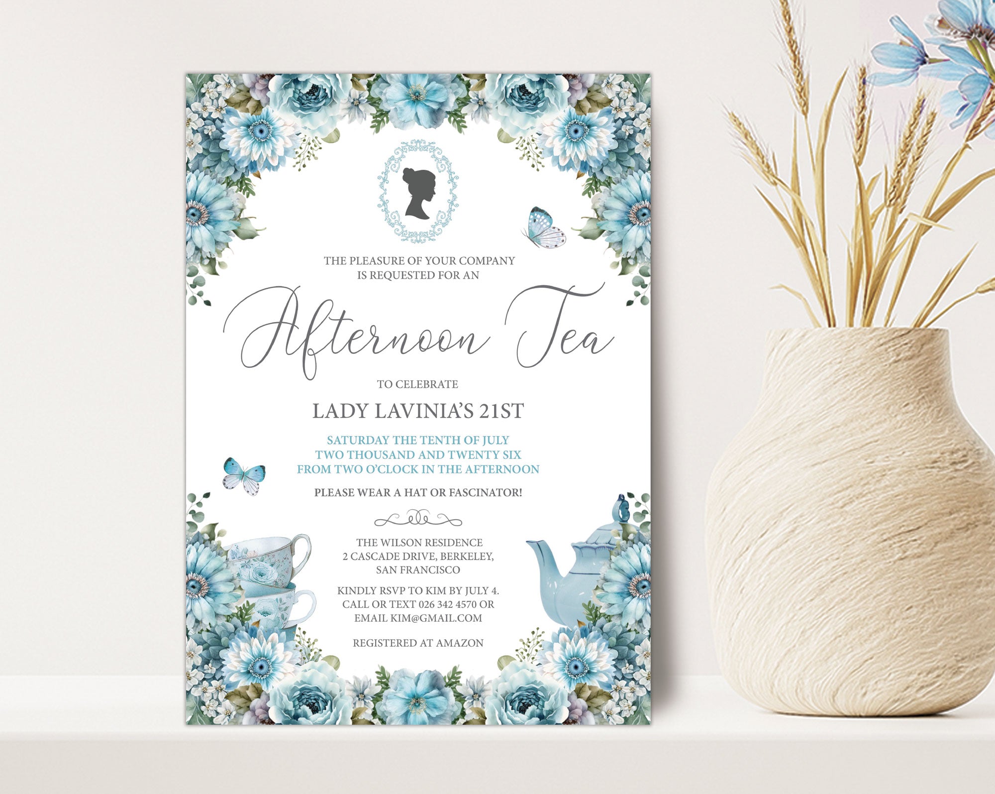 pretty blue flower Invitation card for an afternoon tea event with bridgerton-inspired cameo on a white surface next to a vase of dried flowers.