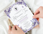 A floral tea invitation card being held by two hands over a white satin fabric background with dried flowers. The card features purple lavender illustrations, elegant black script text, and a silhouette portrait frame at the top.