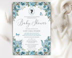 regency baby shower invitation with cameo, teapot and dusty blue flowers laying on a white cloth with a knitted baby pacifier next to it