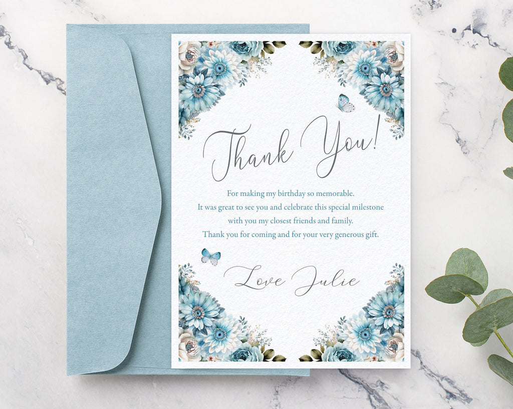 Floral thank you card with a blue envelope on a marble surface