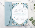 Floral thank you card with a blue envelope on a marble surface