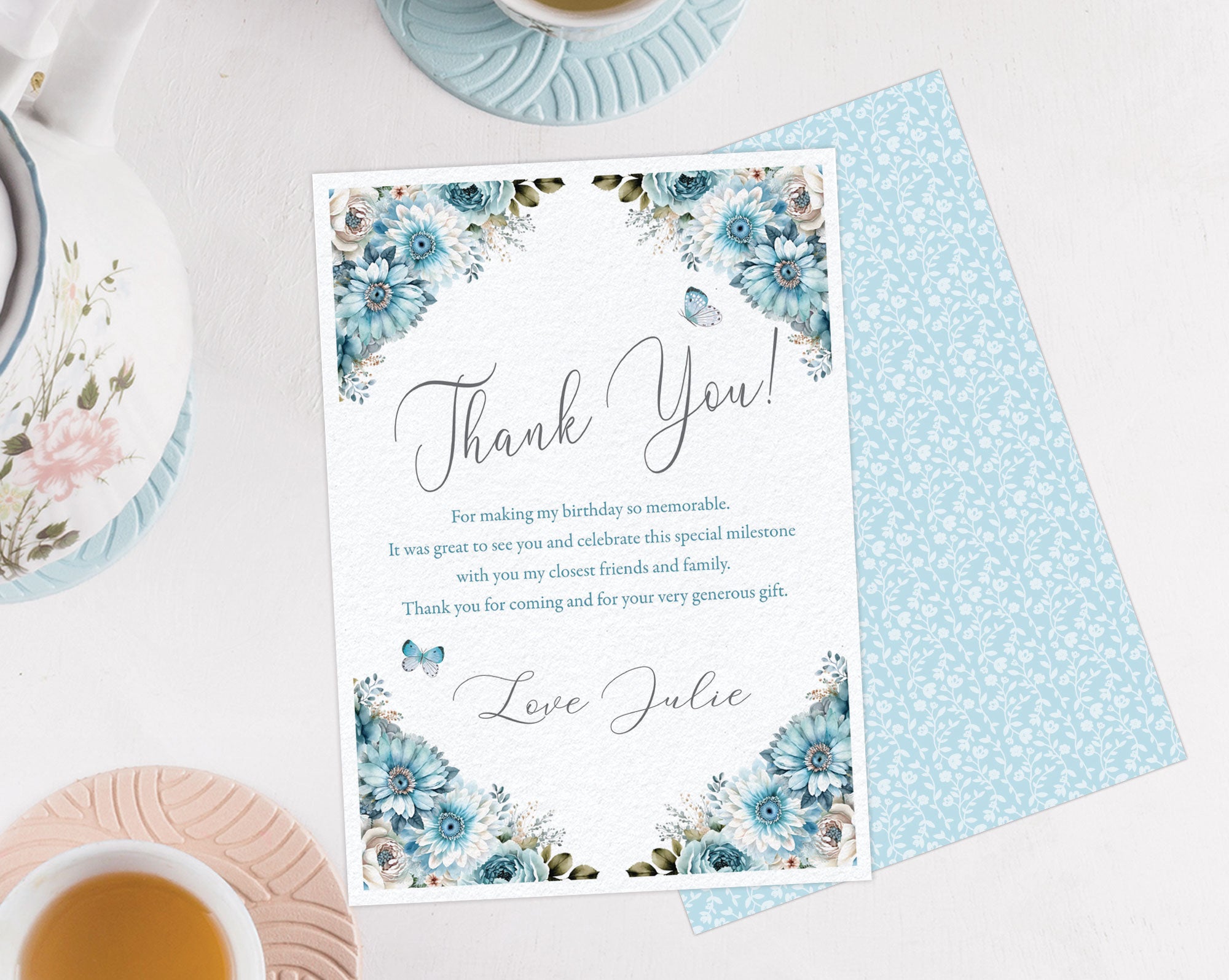 Pretty blue flower thank you note showing the blue pattern back on a white background next to a tea set