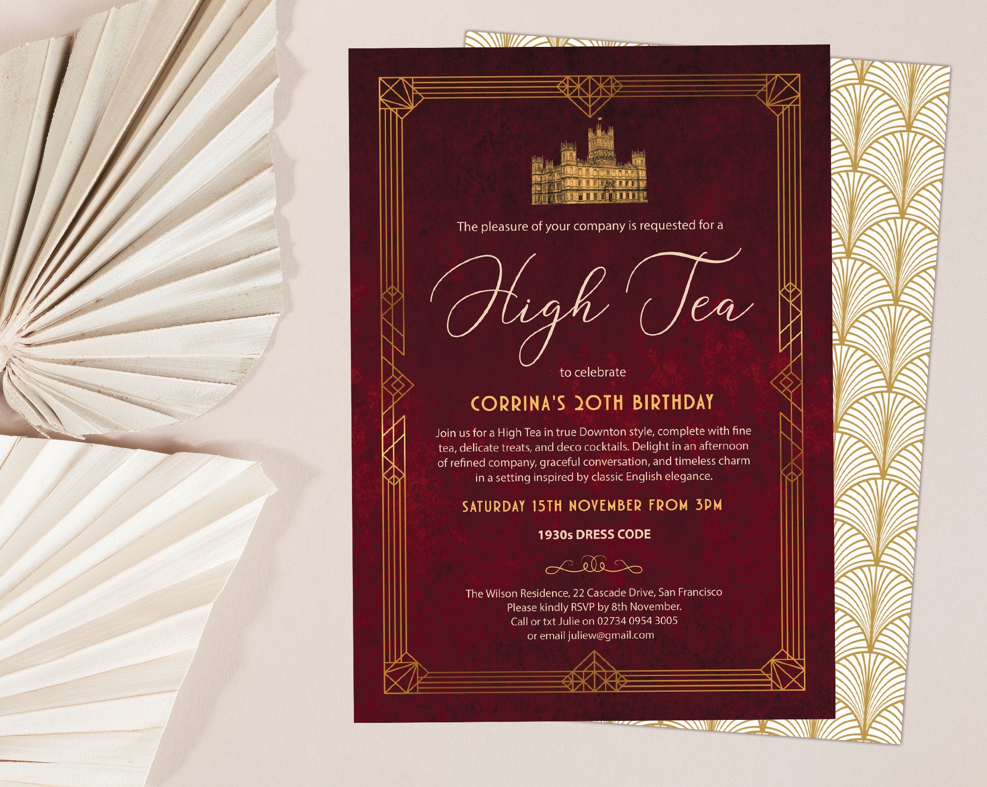 downton abbey inspired high tea invitation with hyclere house, gold border and art deco pattern back laying on a beige background with dried leaves