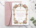 Pretty thank you note with pastel peonies, gold freame, cameo graphics laying on a blush pink envelope on a marble surface