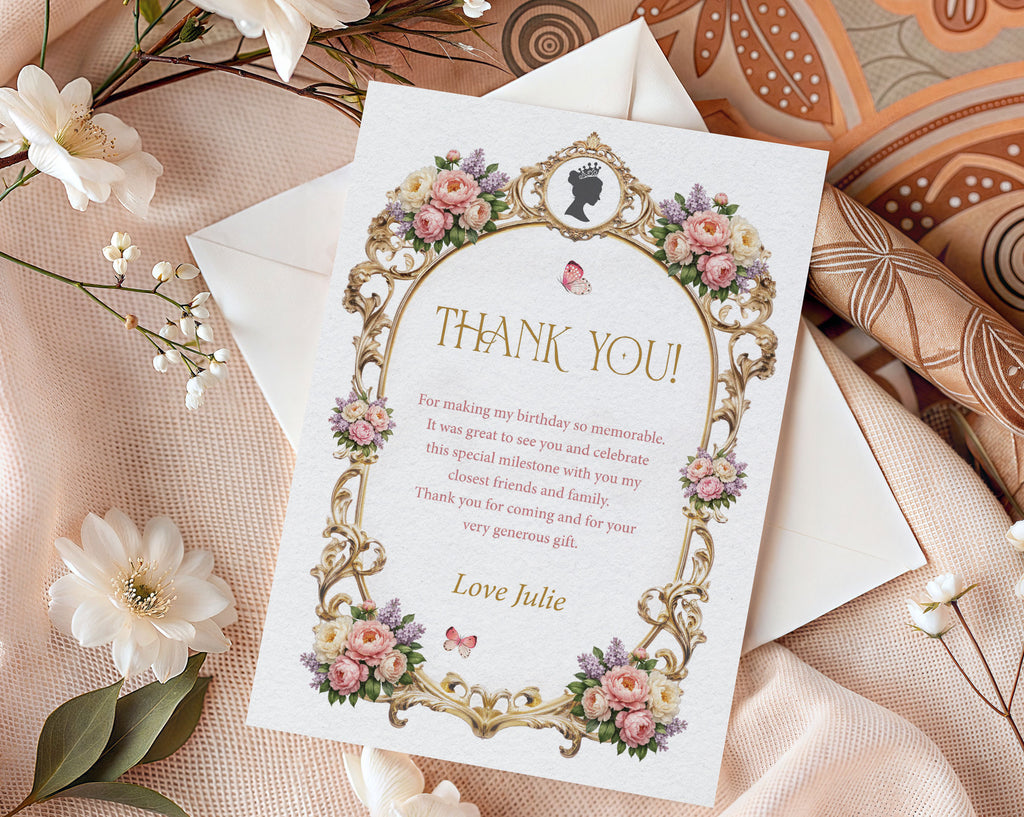 Elegant mockup of a royal thank you note with pastel peony flowers, gold frame and cameo, laying on a white envelope next to white silk and batik cloth