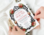two hands holding a regency gothic high tea invitation with red and pink flowers, ornate black frame, cameo, teapot and cups with a white silk background behind
