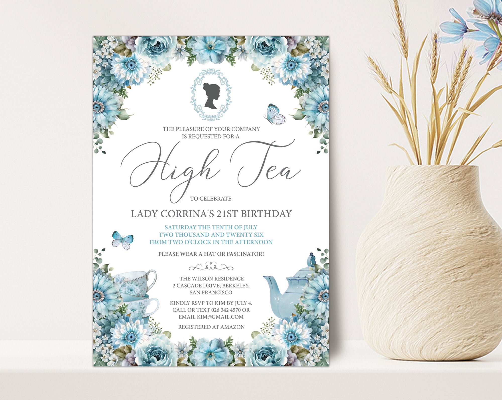 pretty blue flower Invitation card for an high tea event with bridgerton-inspired cameo on a white surface next to a vase of dried flowers.