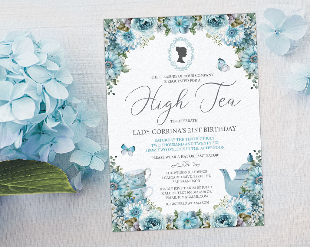 elegant dusty blue flower Invitation card for a high tea celebration on a white surface next to blue hydrangea