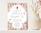 a 5 x 7 mother and daughter tea invitation standing up against a beige wall next to a vase of dried flowers