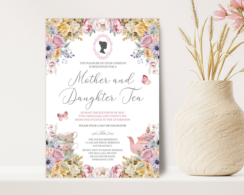 a 5 x 7 mother and daughter tea invitation standing up against a beige wall next to a vase of dried flowers