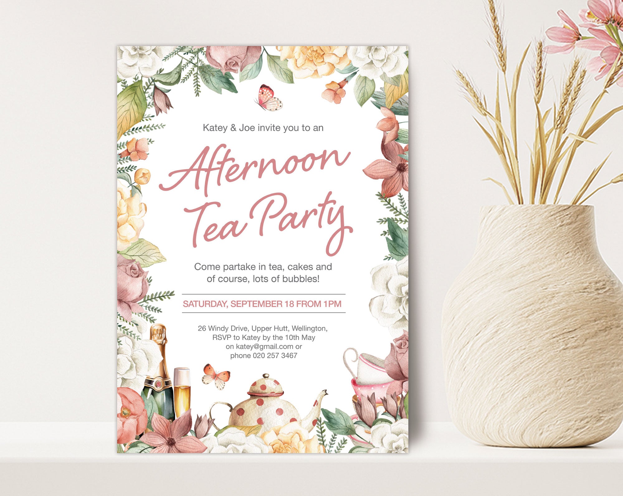 an afternoon tea party 5 x 7 invitation leaning up against a beige wall next to a clay vase with dried flowers
