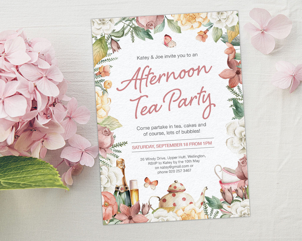 a 5 x 7 afternoon tea invitation laying on a grey background next to a pink hydrangea flower