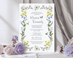 a bridal shower luncheon invitation leaning up against a grey curtain with purple and white roses next to it