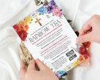 two hands holding a rainbow tea church rainbow money raising event invitation with bright flowers, gold cross and teapot, with a white silk cloth in the background