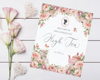 Invitation card for a high tea event with floral design on a wooden surface.