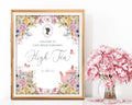 Pretty pastel high tea sign in a gold frame with floral design, cameo next to pink flowers in a vase.