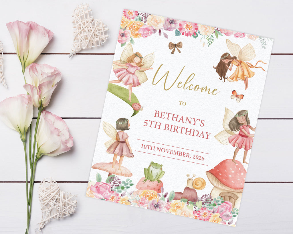 a pretty 8 x 10 fairy garden tea party welcome sign laying on a grey wooden surface next to some lilly's and decorative hearts
