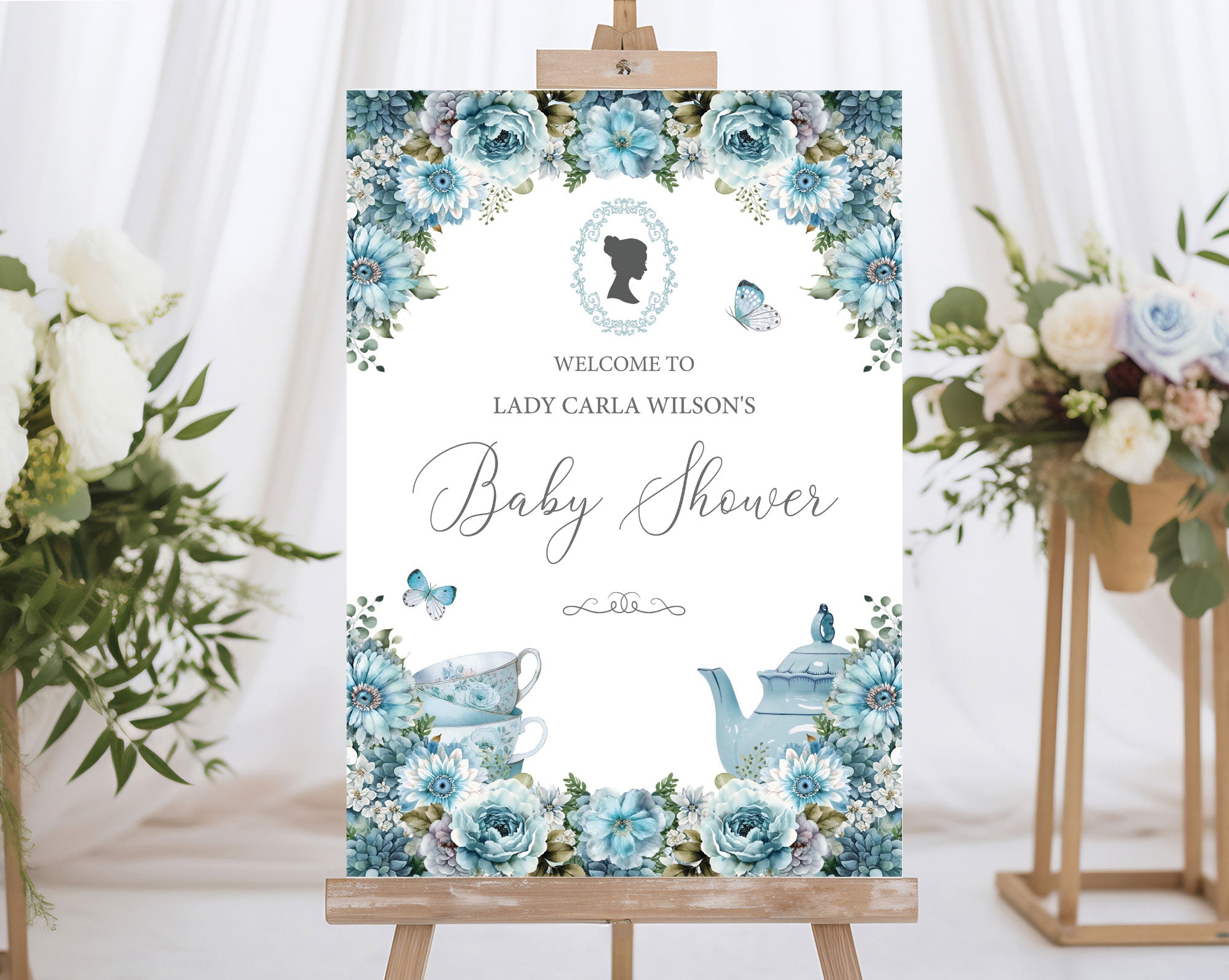 elegant A1 baby shower welcome sign on a wooden easel with white curtains and flowers on stands in the background