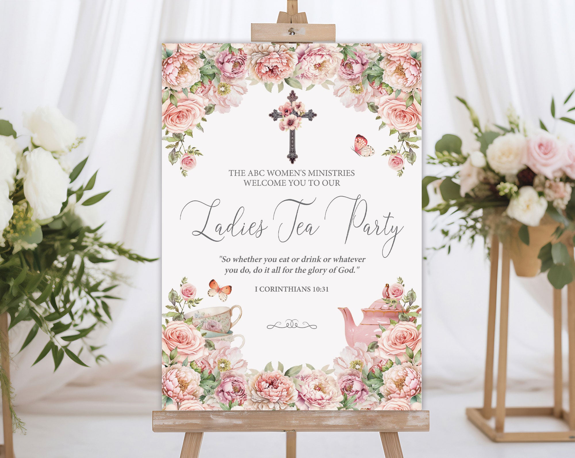 A1 elegant blush pink women's ministries tea welcome sign on an easel next to some flowers on stands with a white curtain in the background