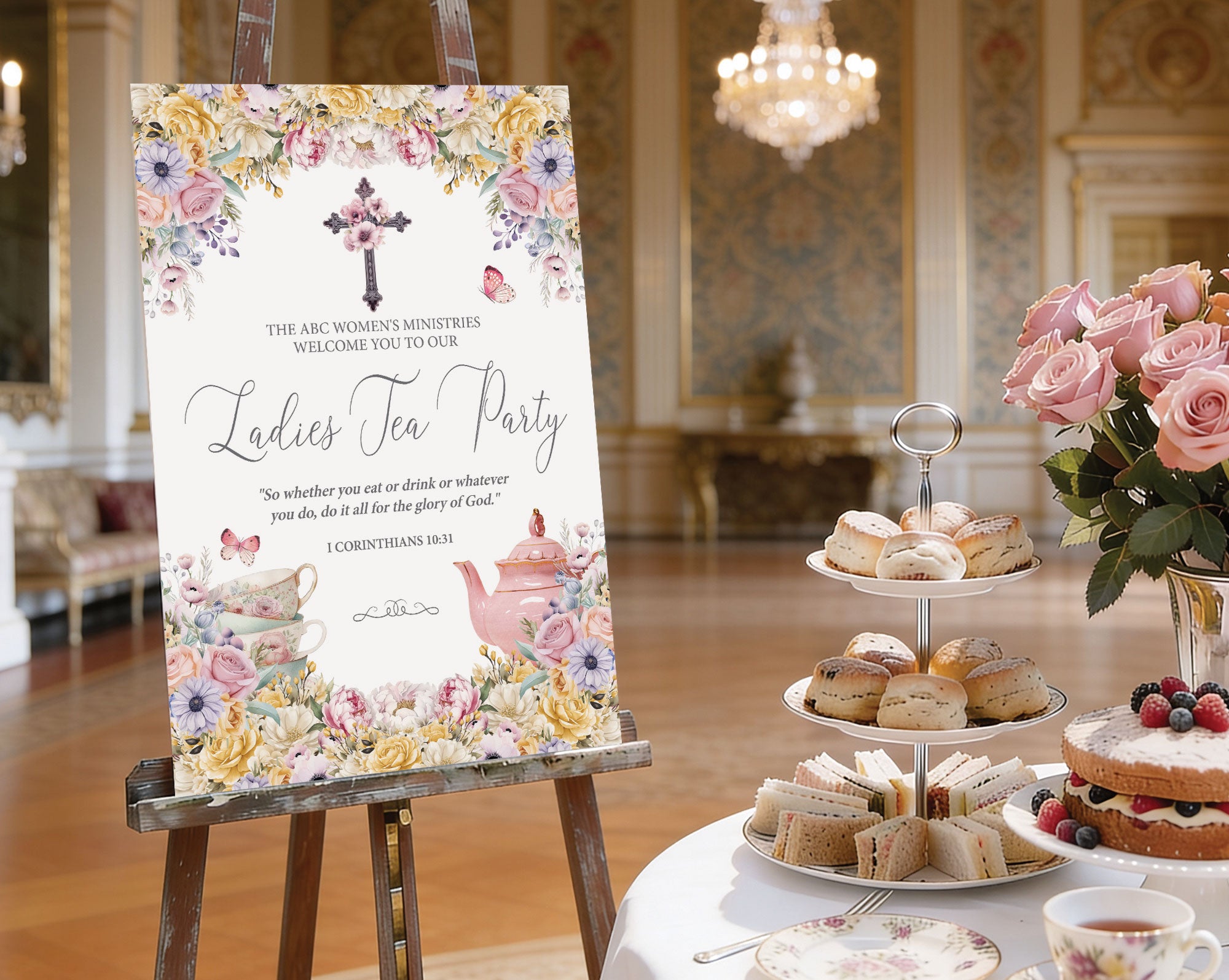 A1 ladies tea party welcome sign with christian flower cross, pastel florals and teapot, on a wooden easel next to a round white tea table set with a tiered stand with sandwiches and cakes, pastel flowers in a vase and a elegant room in the background