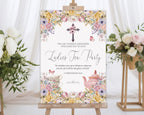 A1 elegant women's ministries tea welcome sign on an easel next to some flowers on stands with a white curtain in the background