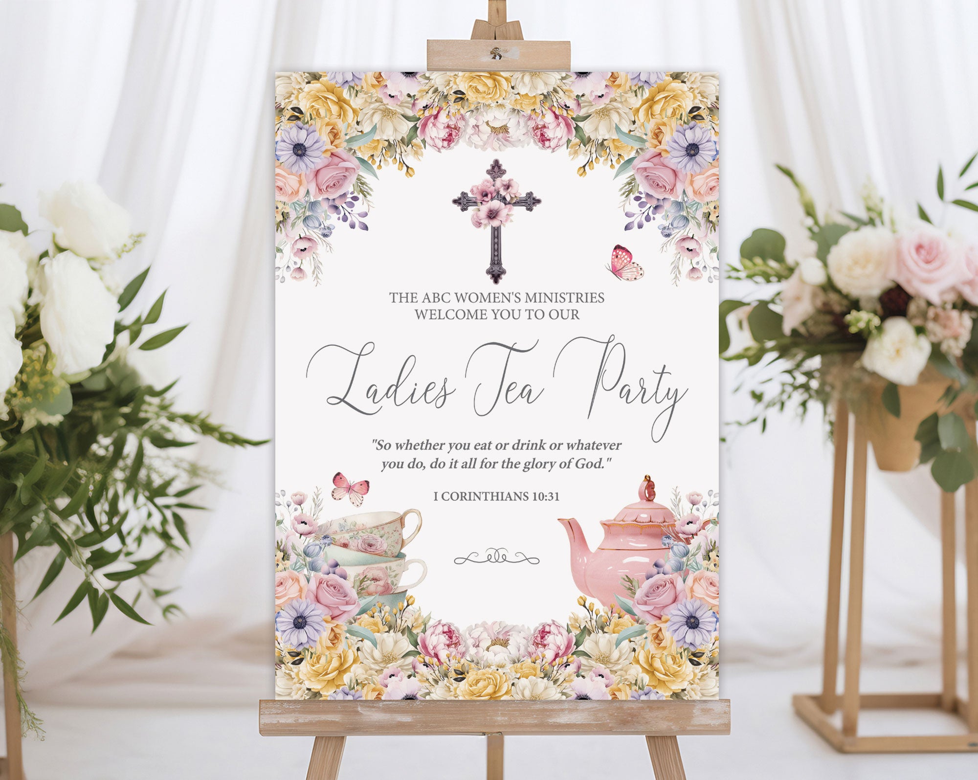 A1 elegant women's ministries tea welcome sign on an easel next to some flowers on stands with a white curtain in the background