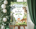 A1 dinosaur and volcano party welcome sign on an easeal in front of a window with green curtains and some greenery with white balloons