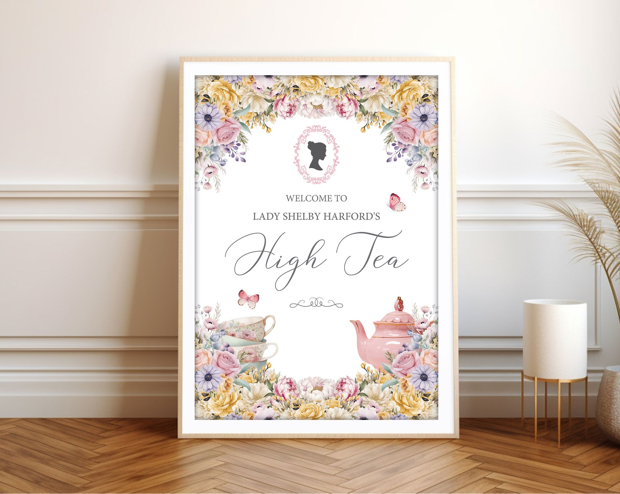 Framed welcome sign with pastel flowers, pink cameo, butterflies and teapot leaning up against a wall