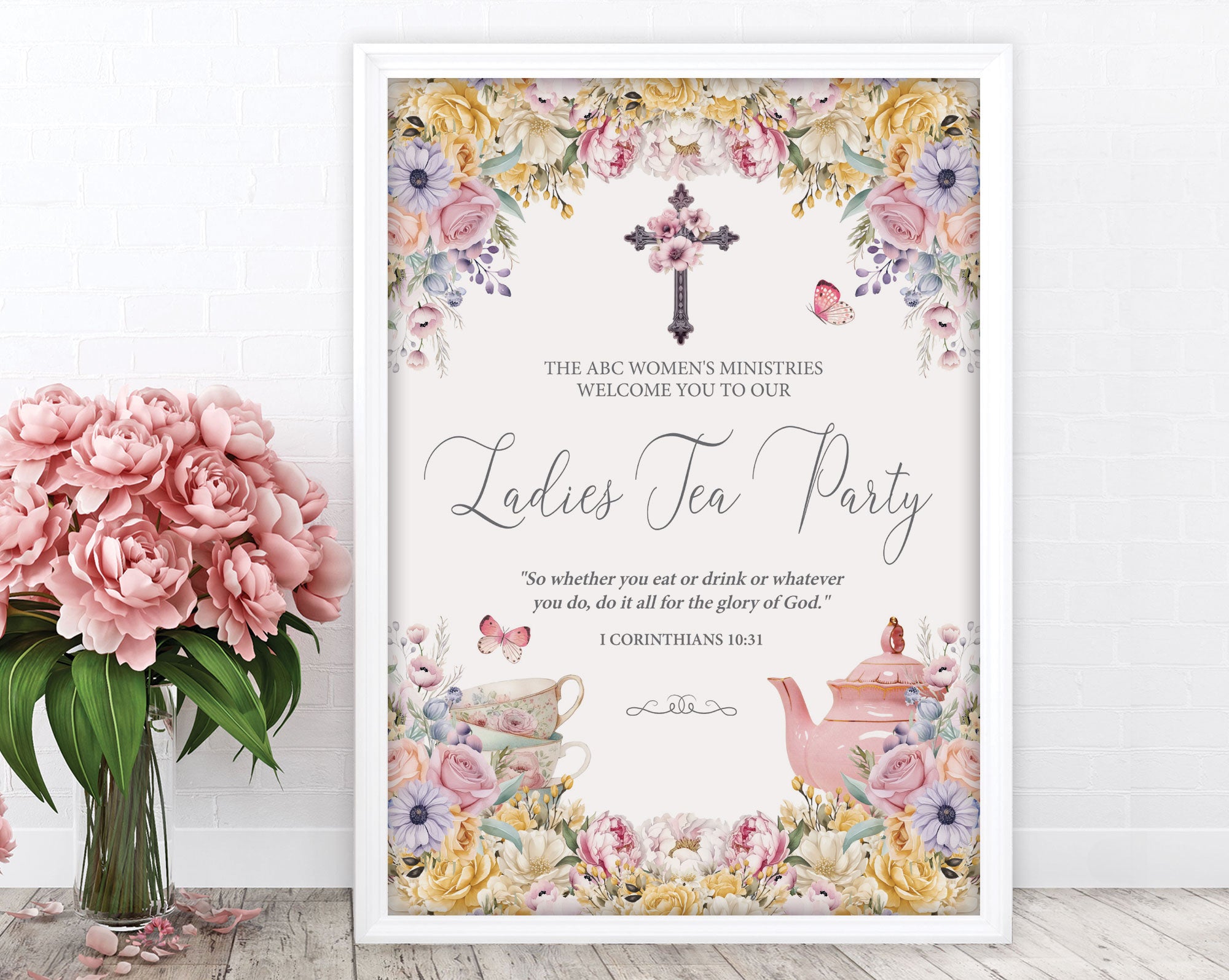 an A2 elegant pastel ladies tea party welcome sign in a white frame leaning up against a white wall next to some pink flowers in a vase