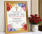 A pretty A2 Church Rainbow tea welcome sign in a gold frame with flowers and gold cross graphics on a table leaning up against a church wall with some red carnations in a vase next to it