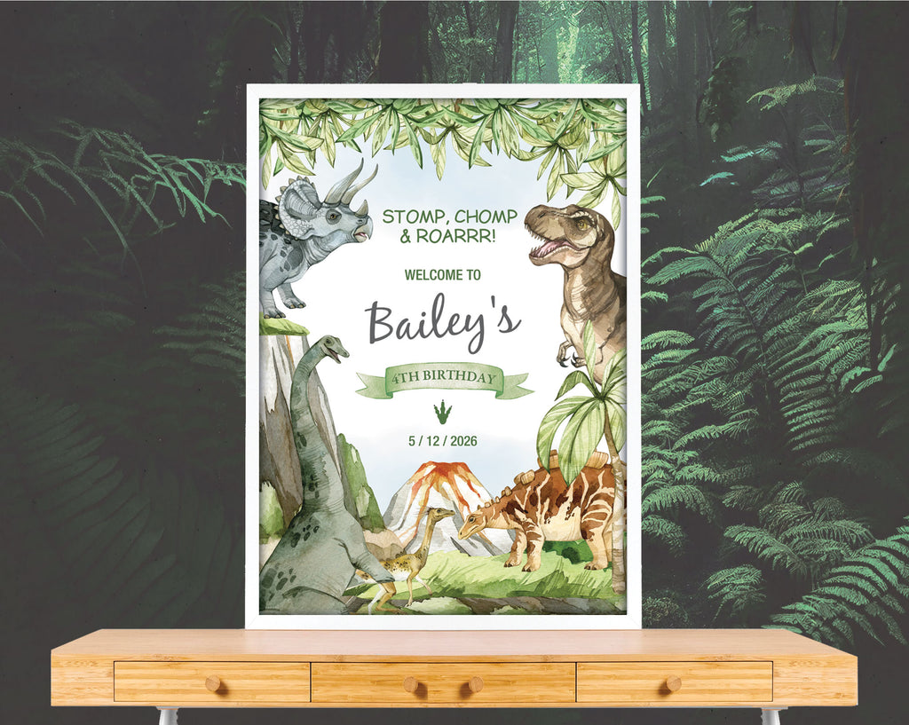A2 dinosaur party welcome sign with volcano in a white frame leaning on a forest wallpaper wall on a wooden table