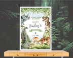 A2 dinosaur party welcome sign with volcano in a white frame leaning on a forest wallpaper wall on a wooden table