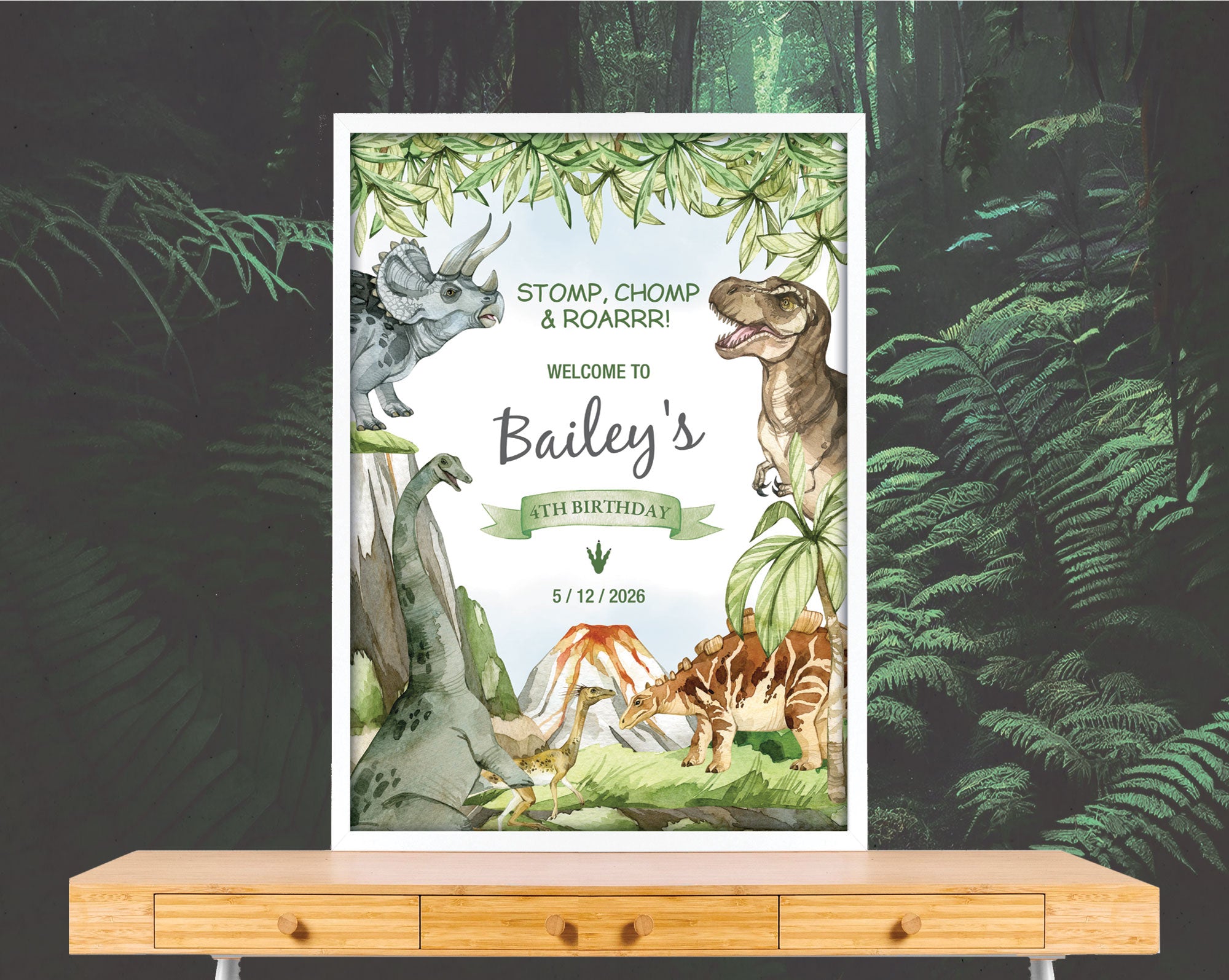A2 dinosaur party welcome sign with volcano in a white frame leaning on a forest wallpaper wall on a wooden table