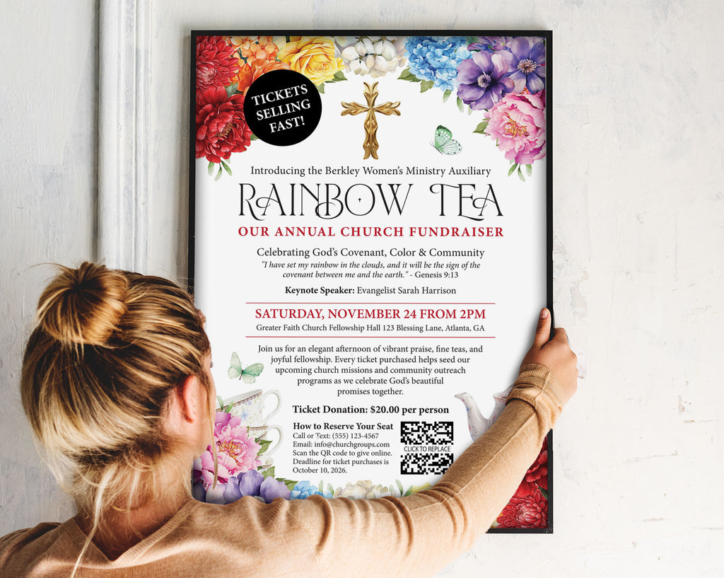 a lady putting up an A3 church rainbow tea fundraising poster in a black frame on to a wall