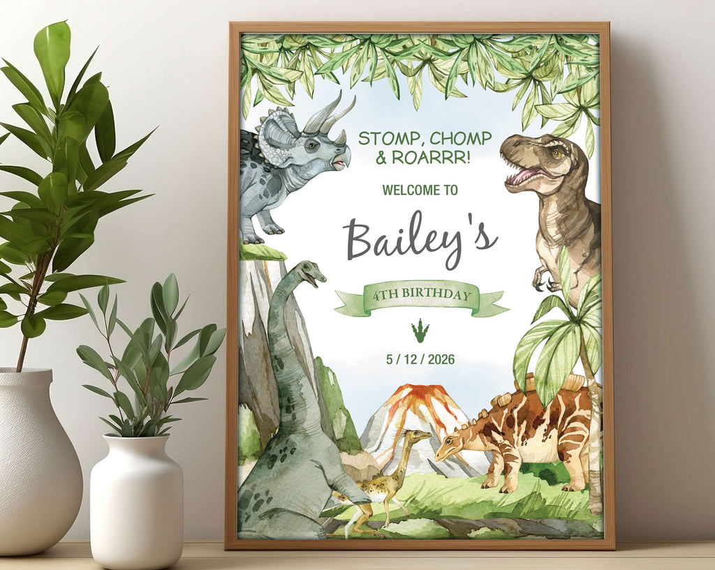 A3 kid's dinosaur party welcome sign with various dinosaurs, volcano and prehistoric forest graphics, in a wooden frame, leaning on a beige wall next to two white vases with greenery
