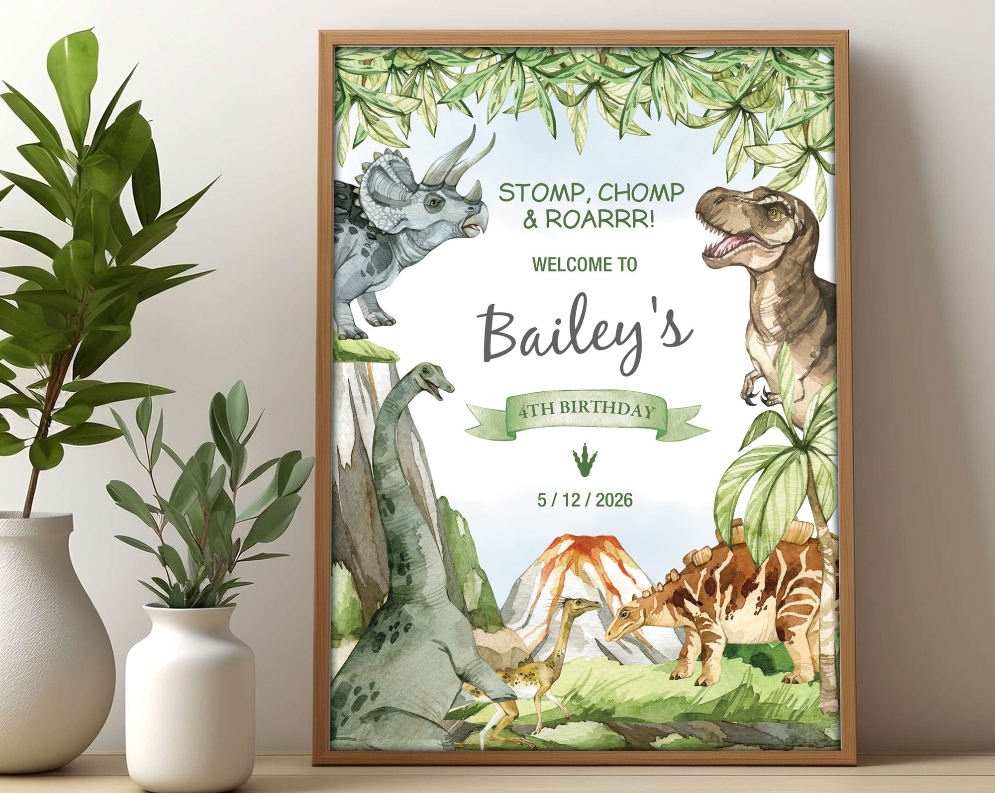 A3 kid's dinosaur party welcome sign with various dinosaurs, volcano and prehistoric forest graphics, in a wooden frame, leaning on a beige wall next to two white vases with greenery