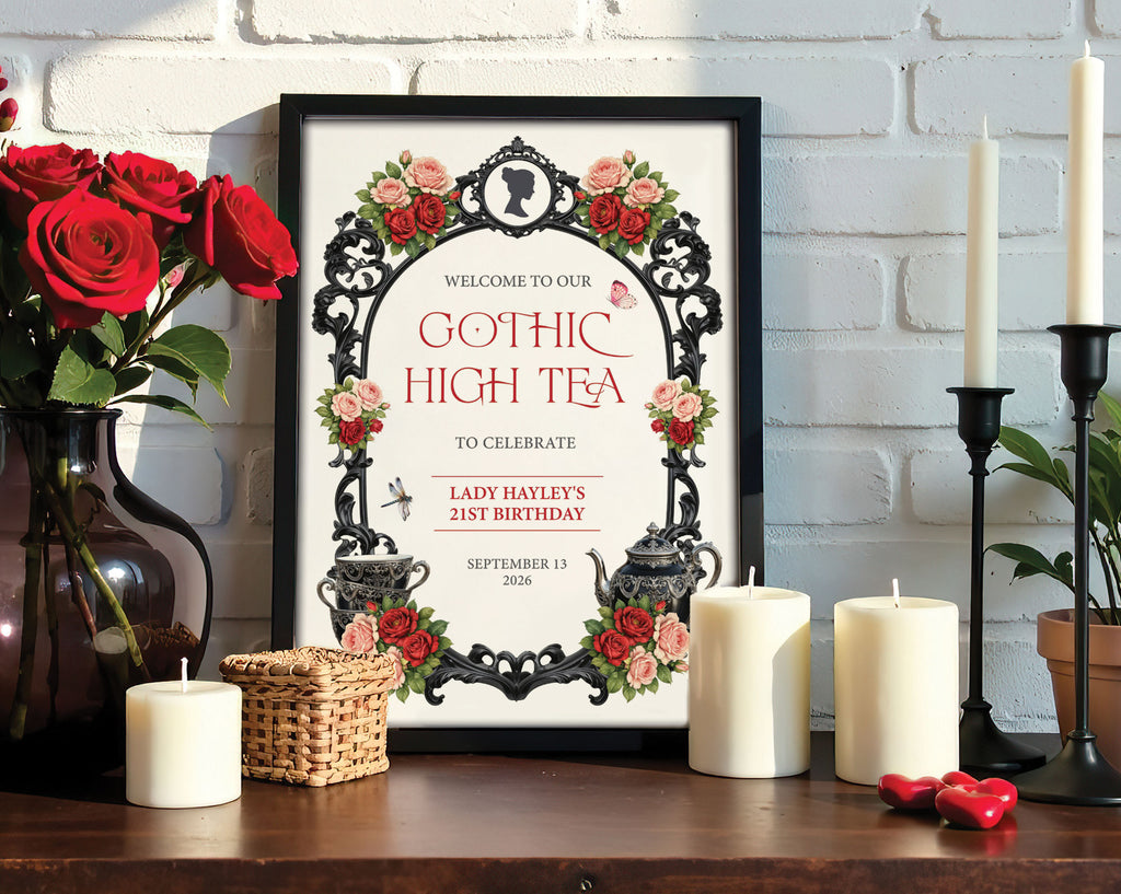 8 x 10 gothic high tea welcome sign with black ornate frame and regency cameo in a black frame leaning up against a white brick wall next to red roses and candles