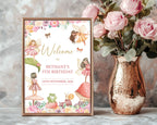 fairy garden tea party A3 welcome sign in a wooden frame, leaning up agains a grey patterned wall next to some pink flowers in a brass colored vase
