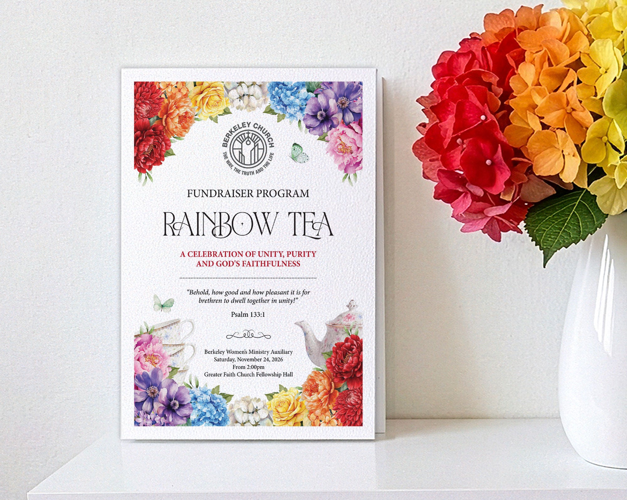 An A4 fundraiser program poster titled 'Rainbow Tea' with colorful floral illustrations and a teapot illustration, displayed on a white shelf leaning against a white wall, next to a white vase of vibrant rainbow hydrangeas.