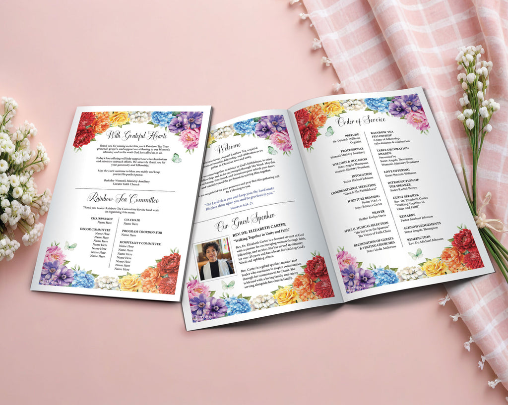 An open printed A4 Rainbow Church Tea event program laid on a soft pink surface, surrounded by small white flowers and a pink plaid fabric. The booklet has colorful floral watercolor flowers and printed program text