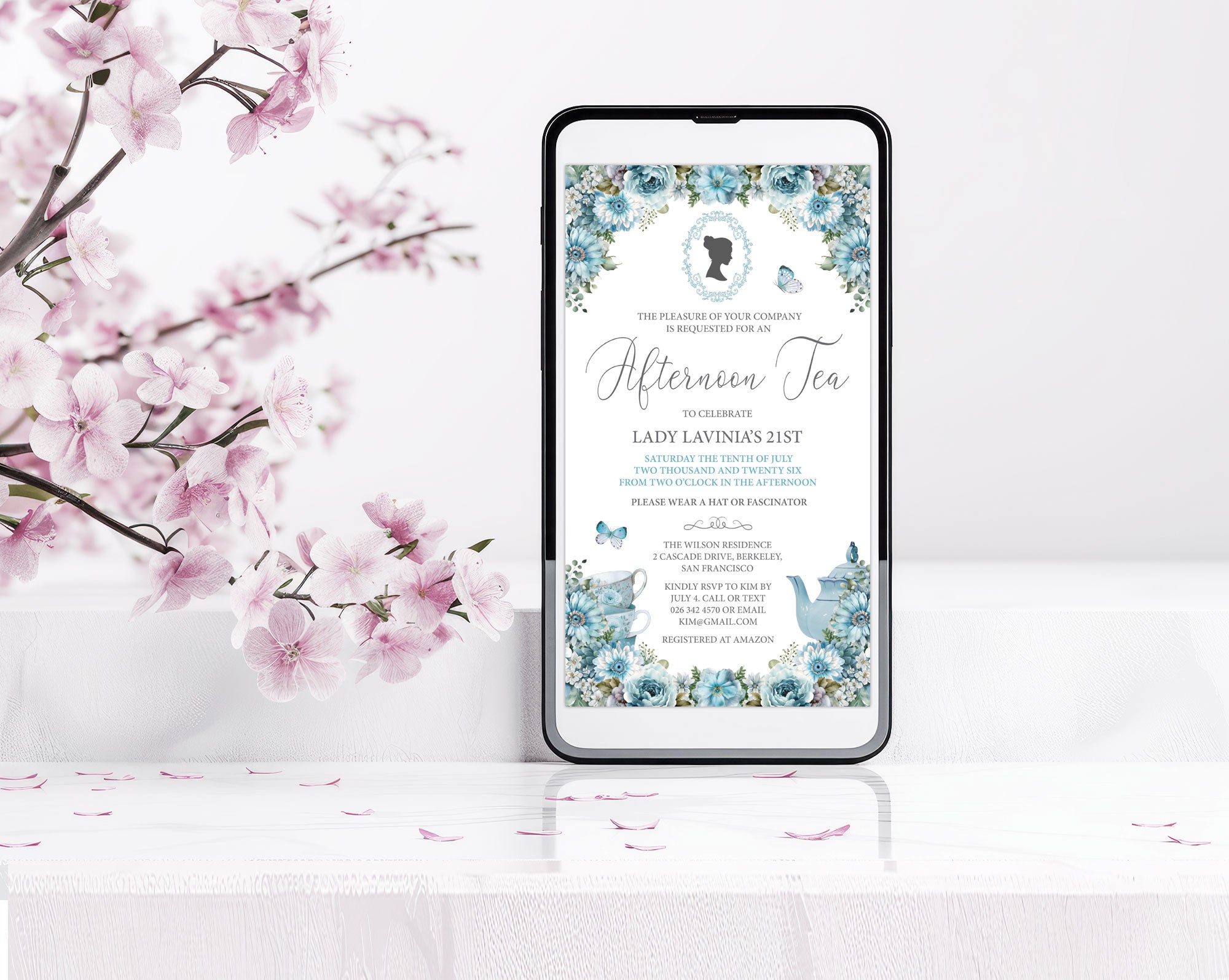 Phone displaying blue flower invitation for a afternoon tea party with a bridgerton inspired cameo an afternoon tea invitation with cherry blossoms in the background