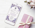 A white smartphone lying on a white wood surface displays a purple floral invitation design for an afternoon tea. A pink gift box tied with a cream ribbon sits beside it, with pale pink flowers in the top-right corner.