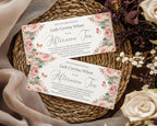 Two pink floral-themed vouchers on a woven mat with flowers around